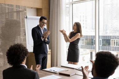 Çeşitli üyelerden oluşan grup el çırpıyor, sunumu kabul ediyor, başarıları veya meslektaş terfisini kutluyor, başarılarını kutluyor, yeni takım üyesini karşılıyor veya toplantıyı bitiriyor