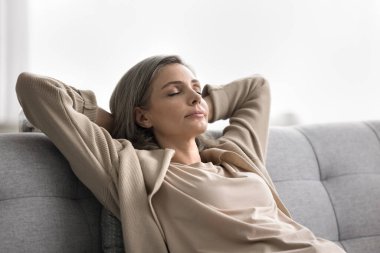Stressiz sükunet. Kafa portresi sakin, sakin, yaşlı bir kadın. Huzur dolu, tembelce inzivaya çekilmiş, kanepede uzanmış, elleri başının arkasında, gözleri kapalı, huzur dolu, yalnızlığın tadını çıkar.