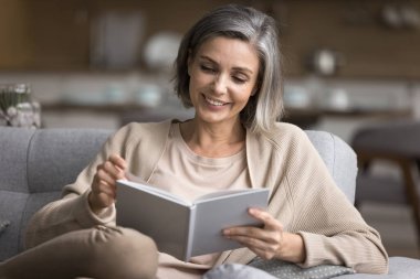 Gülümseyen 50 'li yılların kadınları kanepede oturup kağıt ders kitabı okuyarak kendi kendilerine kitap okuyorlar. Güzel bir hobi için akşamları evde geçiriyorlar. En çok satan yazarlarla fantezi dünyasını keşfediyorlar.