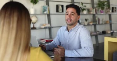 Genç İspanyol adam elini uzatıyor, kadın müşteriyle tokalaşıyor ya da anlaşma jestiyle görüşmeyi sonuçlandırmak için başvuruyor, karşılıklı saygı gösteriyor. Anlaşmak, ortaklık kurmak.