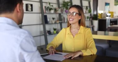 İş kadını baş müzakereci, modern iş yerinde masa başında oturan erkek müşteriyle tokalaşıyor. Profesyonel bilgiyi kanıtlamak, şirket hizmetlerini satmak, ortaklık kurmak, anlaşma yapmak.