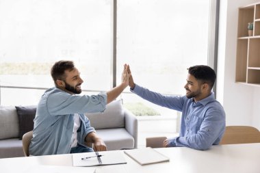 Ortak başarıyı paylaşan, projeyi tamamlayan, olumlu sonuç ve satış artışı elde eden, beşlik çakan, birlik, sinerji ve saygı gösteren iki mutlu erkek takım arkadaşı. Ortaklık, takım çalışması