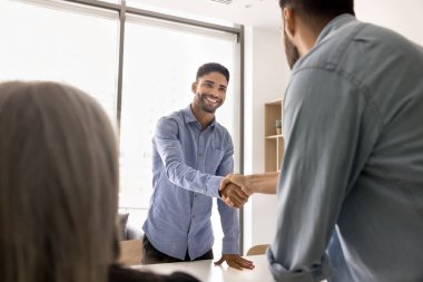 Genç işadamı, yeni takım üyesi, müvekkil ya da ortağı selamlıyor, toplantı odasında toplanıyor, takdir ve saygı gösteriyor, ticari anlaşma, ortaklık ya da karşılıklı anlayışı doğruluyor