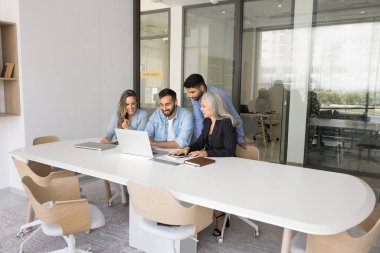 Genç ve olgun iş arkadaşları ortak online proje üzerinde işbirliği yapıyor, verileri analiz ediyor, raporları veya analizleri yorumluyor, beyin fırtınası fikirlerini yorumluyor, yaratıcı içgörüler veya stratejiler üretiyor ve paylaşıyor