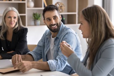 Çok ırklı, pozitif takım arkadaşları, baş sohbet, orta yaşlı bayan meslektaşın başkanlığındaki brifinge katılma, görüş bildirme ve çözüm paylaşımı. Takım çalışması, iş ortaklarının görüşmeleri