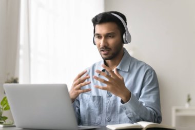 Görüntülü konuşma. Dijital kulaklıklı kendine güvenen genç adam, internet kamerası kullanarak müşteriyle konuşuyor. Uzaktan profesyonel danışma destek istemcisi, sanal sınıf öğrencilerine öğretmenlik yapıyor.