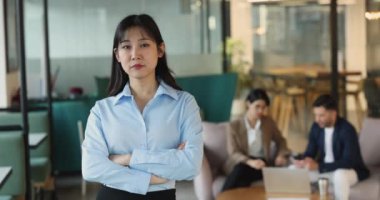 Profesyonel çalışma alanında kendine güvenen Asyalı kadın portresi, gündelik giysiler içinde modern iş yerinde kollarını kavuşturmuş duruyor, kameraya bakıyor, liderlik ve başarı yayıyor.