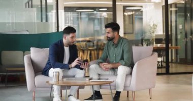 Akıllı telefondaki yeni yapay zeka iş uygulamasını meslektaşına gösteren, iş görevleri, veriler veya proje güncellemeleri ile ilgili bilgileri açıklayan veya gösteren, mobil uygulamayı inceleyen, çevrimiçi içeriği sunan adam