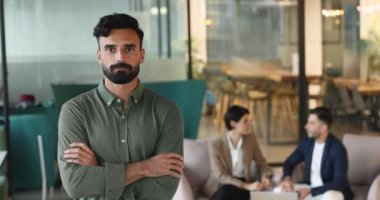 Yakışıklı gülümseyen Arap işadamı kameraya bakıyor, ortak çalışma alanında duruyor, liderlik ve beceri yayıyor. Hizmetler, insan kaynakları, liderlik, iş dünyası ofis portresi