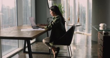 Ofiste tek başına çalışan meşgul yönetici kadın, dizüstü bilgisayarda yazı yazma, pazarlama stratejisi geliştirme, makale yazma, modern iş alanında iş için teknolojiyi kullanma