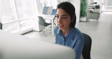 Arama merkezindeki kadın mikrofon ve bilgisayar kullanarak müşteriyle konuşuyor, teknik destek sağlıyor, müşterilere rehberlik ediyor, ürünler, hizmetler veya politikalar hakkında bilgi veya sorular soruyor