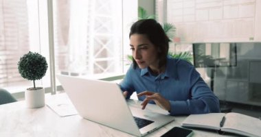 Latin iş kadını, modern ofiste masa başında oturmuş, e-posta, bildirim ya da haber okurken heyecan ve sevinç hissediyor, mesleki başarıyı kutluyor, anlaşmayı bitiriyor, büyük görevleri başarıyor.