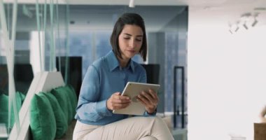 İş yerinin modern çalışma alanındaki tablet üzerinde çalışan Brezilyalı iş kadını, rapor veya sunum hazırlama, iş için bilgi araştırması, yaklaşan toplantılar, etkinlikler veya görevler planlama