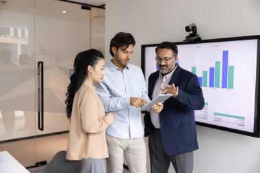 Toplantı odasında tablet kullanan çok ırklı iş arkadaşları ekibi, web sitesi ekommerce platform pazarlama raporunu, finansal analizleri, çevrimiçi içeriği, takım çalışması iletişimini analiz ediyorlar.