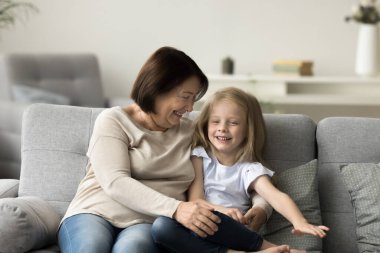 Sevimli çocuk, olgun bir büyükanneyle vakit geçirir, çok nesilli sevgi dolu bir aile evdeki kanepede dinlenir, gülümser, oynar, güler, eğlenir, birlikte vakit geçirir, iyi sıcak ahenkli ilişkiler kurar, anlayışlı olur.