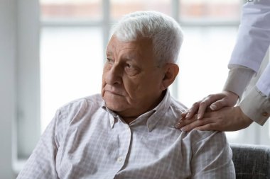 Destekleyici kadın bakıcı huzurevinde yalnız kalan 80 'lerin erkek hastalarına yardım ediyor, ilgili kadın hemşire mutsuz, sıkıntılı yetişkin adama hastanede destek oluyor, yaşlı sağlık hizmetleri kavramı...
