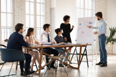 İki farklı iş sunucusu iş arkadaşlarına, yöneticilere istatistiksel verileri açıklarken grafiklere, konuşmalara, sunumlara, iş projesi planlarına işaret ediyor. Geniş açı