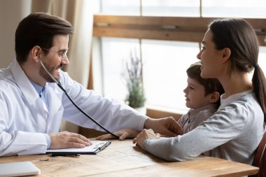 Gülümseyen çocuk doktoru, nefes, akciğer ve kalp atışlarını kontrol eden, beyaz üniformalı, stetoskop kullanan dost canlısı doktor, çocukların sağlık kontrolü ve sağlık sigortası konsepti.