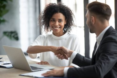 Gülümseyen çok ırklı iş ortakları ofis toplantısında el sıkışıyor, çeşitli meslekdaşlar mutlu bir şekilde selamlaşıyor iş adamları brifingde el sıkışma anlaşması yapıyor, tanıdık konsepti