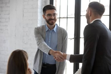 İş adamı selamlaşması toplantıda gülümseyen erkek işverenle tanışın, iş ortakları brifingde tokalaşma anlaşması yapın, ofis pazarlığında anlaşma yapın, tanıdık konsepti oluşturun.