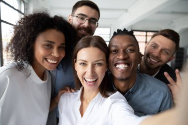 Mutlu, çok ırklı meslektaşların yakın plan çekimleri birlikte hücrede kendi portresini çekmeleri, çok ırklı iş arkadaşlarının gülümsemeleri ofiste selfie için poz vermeleri, arkadaşlık konsepti.