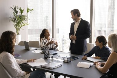 Ofiste iş toplantısı. İş adamları konferans masasının etrafında toplandılar, konuşmaları dinlediler, erkek patronla diyalog kurdular, proje planlamasında yer aldılar, beyin fırtınası yaptılar, karar vermelerini sağladılar.