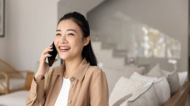 Mutlu, genç Vietnamlı kadın cep telefonuyla konuşuyor, gülüyor, eğleniyor, cep telefonu konuşmasından hoşlanıyor, iletişim kuruyor, başka tarafa bakıyor. Sancak vuruşu