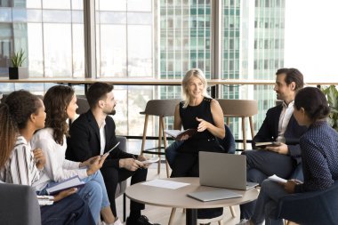 Orta yaşlı bir işletme eğitmeni, genç personelle yaptığı brifingde fikir, deneyim ve mesleki beceriler kazanmak için ofis lobisinde bir araya geldi.