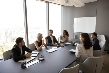 Çok uluslu iş adamlarından oluşan bir grup, konferans odasında işle ilgili sorunları çözüyor, fikirleri, çözümleri paylaşıyor, mali tabloları, bütçe tahsisatlarını gözden geçiriyor, yatırım fırsatlarını tartışıyor