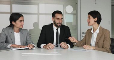 Konferans masasında oturan profesyonel çalışanlar, bayan takım arkadaşlarının açıklamalarını, kesin çözümlerini ve noktalarını dinliyorlar, satış istatistiklerini gözden geçiriyorlar, toplantı odasındaki mali verileri analiz ediyorlar.
