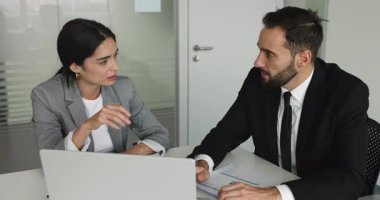 Masada dizüstü bilgisayar ve kağıtlarla birlikte ortak bir görev üzerinde çalışan meslektaşlar. İş kadını partneriyle konuştu, proje güncellemelerini paylaştı, verileri analiz etti, iş ilişkileri ve karar verme sürecine girdi