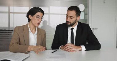 Banka müşterisi, mali danışman ile iş birlikçi toplantı sırasında sözleşmeyi gözden geçirip imzalıyor, gülümsüyor, güven ve saygı jesti olarak görüşmeleri tokalaşarak sonuçlandırıyor. Anlaştık, iş.