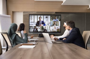 Çeşitli iş adamları sanal toplantıya katılıyor, toplantı odasında toplanıyor, ekran görüntüsü alan bir grup meslektaşı videoya katılıyor, çözümü paylaşıyor, işle ilgili konuları çözüyorlar.