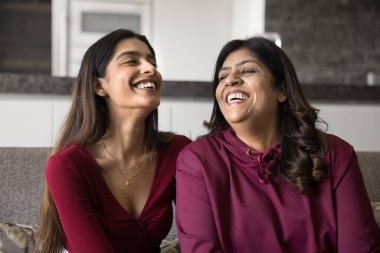 Genç, güzel Hintli bir kadın, orta yaşlı bir anneyle kanepede oturuyor, birlikte gülüyor, haberleri paylaşıyor, şaka yaparken kıkırdıyor, hafta sonu evde pozitif vakit geçiriyor. Aile bağları, bağ ve anlayış