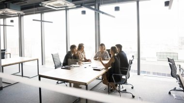 İş adamları konferans masasında oturup işle ilgili konuları tartışıyor, şirketin uzun vadeli stratejisini gözden geçiriyor, potansiyel birleşmeleri veya satın almaları değerlendiriyor. Risk yönetimi, kapalı kapılar ardında pazarlık