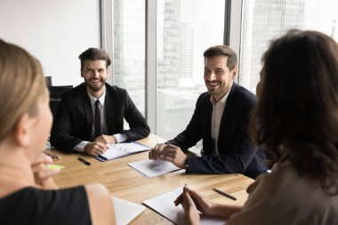 Dört iş adamından oluşan bir grup konferans masasında toplandı, canlı, olumlu tartışmalara giriştiler, başarılı toplantı sonuçlarından memnun görünüyorlar, gelecekteki stratejiyi planlarken iyi bir işbirliği