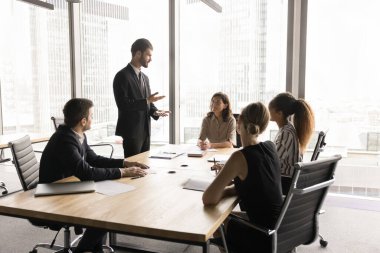 Takım elbiseli bin yıllık Avrupalı işadamı resmi toplantıya liderlik ediyor, hissedarlarla görüşmeler şehir manzaralı yönetim kurulu odasında toplandı. Partiler işle ilgili sorunları ve işbirliğini çözer