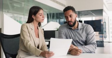Avukat ve müşteri kağıt tartışıyor, ofis masasında oturuyor, danışma toplantısında belge okuyor. Yatırımcı danışmanı finansal danışman, iş arkadaşları sözleşme metni üzerinde çalışıyorlar