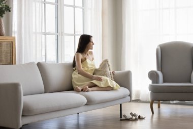 Refahın tadını çıkarıyorum. Mutlu gülümseyen, yaz elbisesi içinde güzel bir kız rahat rahat koltukta oturup lüks bir oturma odasında kendine bak. Geleceği hayal et.