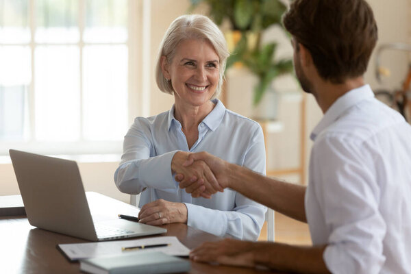 Aged businesswoman handshake greets company client, shaking hands sign of respect, hope for future cooperation, succeed result effective negotiations ending, making deal, hr got job employment concept