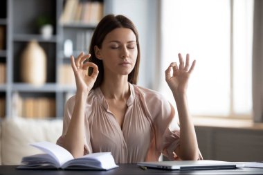 Huzurlu ev hanımı oturma odasında oturur planlama günü boyunca dinlenir. Kişisel organizatör masaya uzanır, ev işlerinden dinlenir, parmaklarını büker, Mudra sembolü meditasyon yapar, yorgunluğu azaltır.