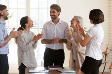 Yönetim kurulunda el çırpan beş farklı işadamı, ayın en iyi çalışanı ve genç ve yaşlı meslektaşlarından takdir gören takım liderini tebrik ediyor. İş kavramında başarı