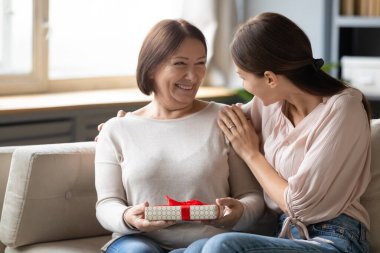 Hayat etkinliği, Anneler Günü, doğum günü konsepti. Yetişkin kız kucaklaşması. Sevgili anne ona hediye paketi hazırladı. Sürpriz hazırladı.