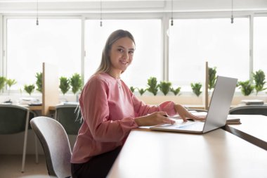 Mükemmel öğrenci kız portresi, hazırlık görevi, öğrenme teorisi, dizüstü bilgisayarla kütüphanede oturarak çalışmak. Gen Z, modern kablosuz teknoloji ve internet kaynaklarını kullanarak yeni bilgiler ediniyor. Eğitim