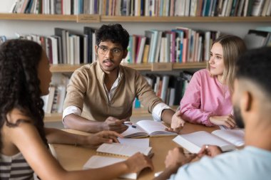 Projeleri tartışan çok ırklı üniversite ya da lise öğrencileri, beyin fırtınası fikirleri kütüphanede masaya oturur, takım çalışmasına katılır, ortak görevi tamamlamak için fikir ve görüşlerine katkıda bulunur.