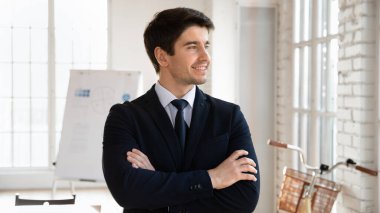 Resmi takım elbiseli bir işadamı gözlerini kaçırıyor, modern yönetim kurulunda kollarını kavuşturmuş, parlak bir gelecek arzusuyla başarı yayıyor. Kariyerde veya iş girişimlerinde büyüme