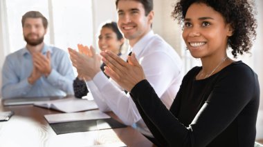 Konferans masasında oturan, alkışlayan, alkışlayan, alkışlayan, sunum koçuna takdirlerini ifade eden çok uluslu seminer veya kurumsal eğitime çok uluslu seyirci katılıyor. Tanınmak