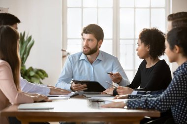 Ciddi yetenekli takım arkadaşları, karar verme, planlama stratejileri ve tahminler için konferans masasında bir araya geldiler. Milenyum takım lideri şirket personeliyle brifing sırasında konuşuyor.