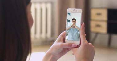 Akıllı telefonlu bir kadın sosyal medya platformunda videolar izliyor ya da sıradan tişört giymiş yakışıklı İspanyol bir adamla görüntülü buluşma ayarlayıp kameraya komik jestler yapıyor..