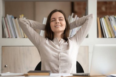 Sakin Kafkasyalı bin yıllık bayan öğrenci sandalyeye yaslanır gözleri kapalı rahatlar, çalışmaya ara verir, işyerinde mutlu bir kız dinlenir huzur ve stresten arınmış konseptin tadını çıkarır.